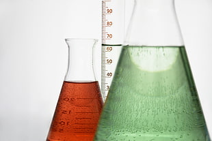 two clear measuring beakers with liquids
